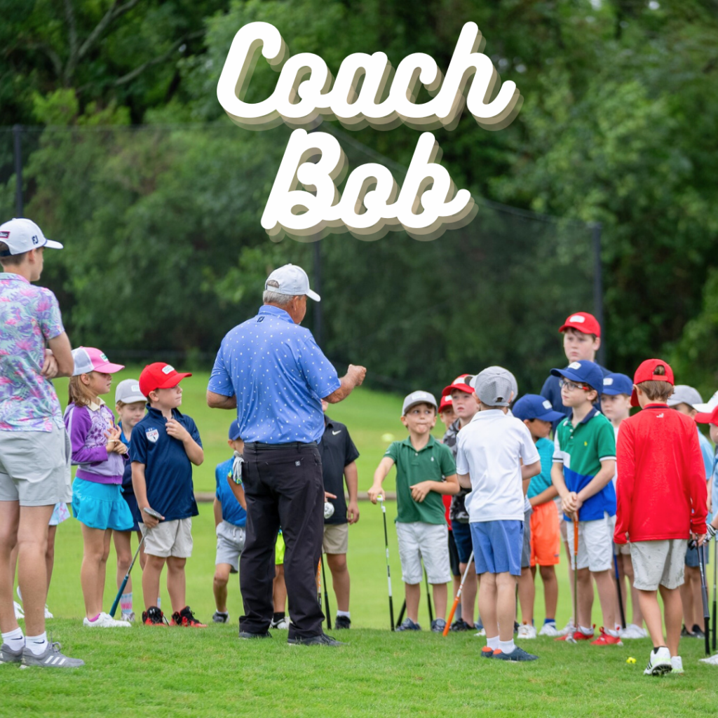 Coach Bob explains a putting technique to a group of kids on the putting range during a youth golf clinic.